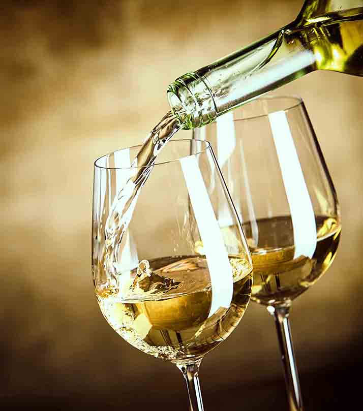 Pouring,Two,Glasses,Of,White,Wine,From,A,Bottle,In