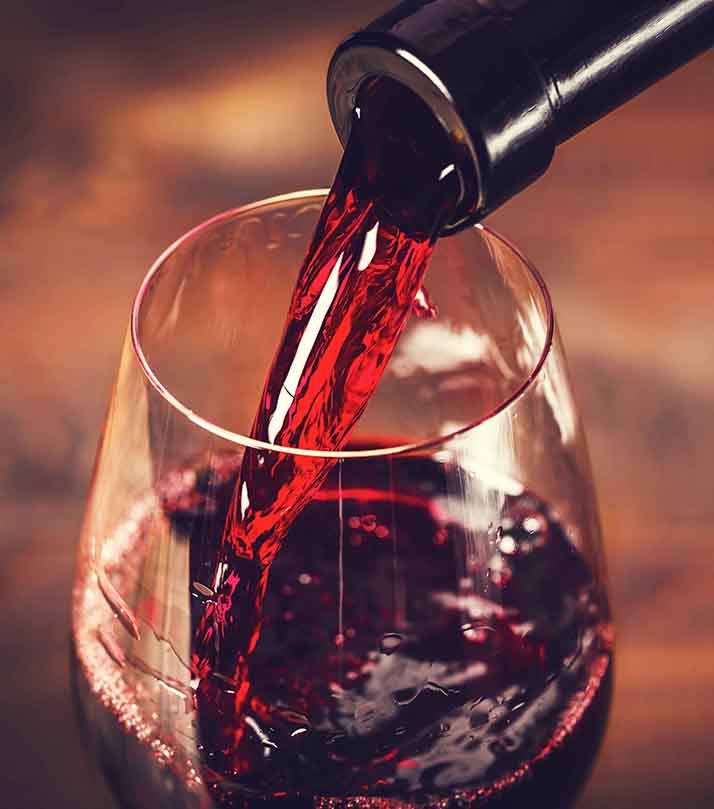 Pouring,Red,Wine,Into,The,Glass,Against,Wooden,Background